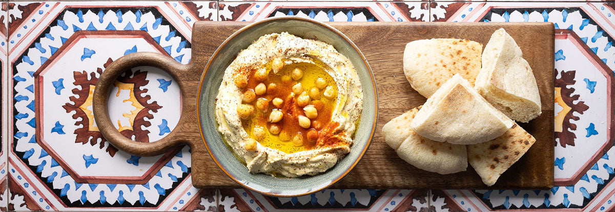 Mamoosh pitta bread and creamy hummus with chickpeas on surface