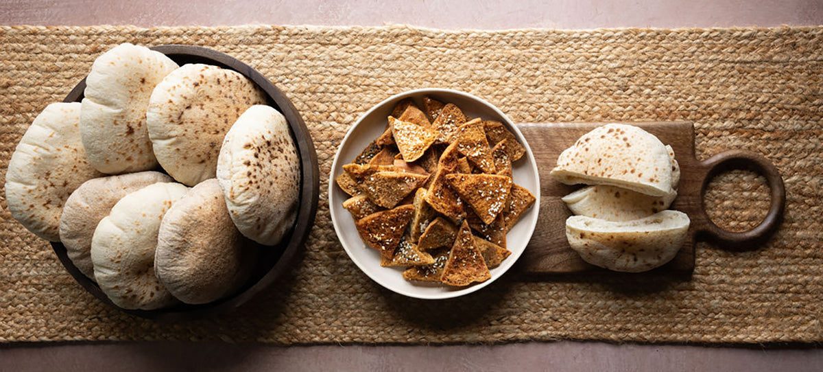 Mamoosh white pitta bread and pitta chips displayed on a straw runner