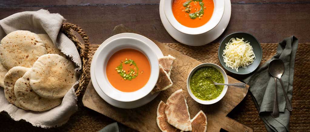 Healthy Mediterranean Eating with pitta breads and bowls of red pepper soups