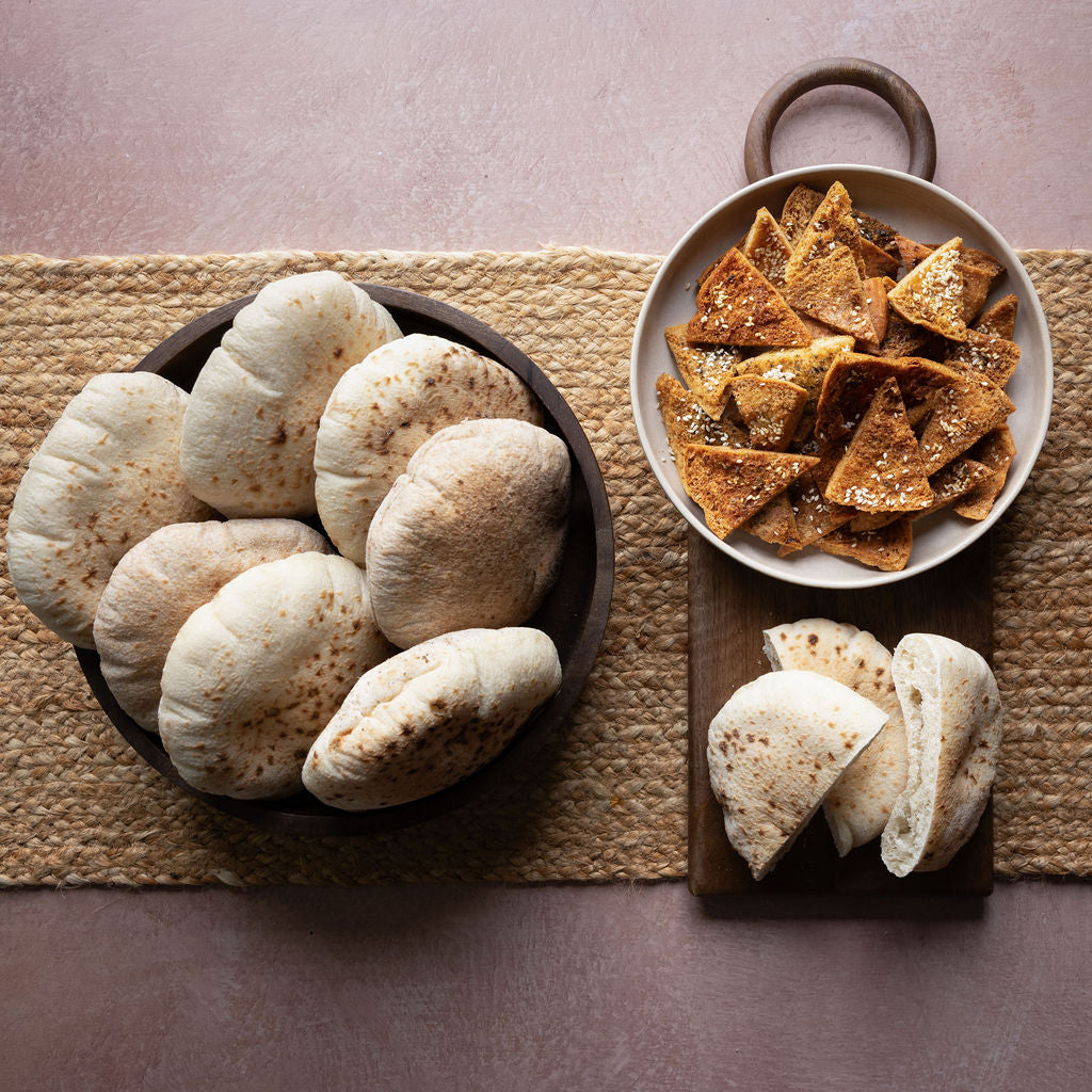 Bowl of pita bread and bowl of pitta chips on a textured surface
