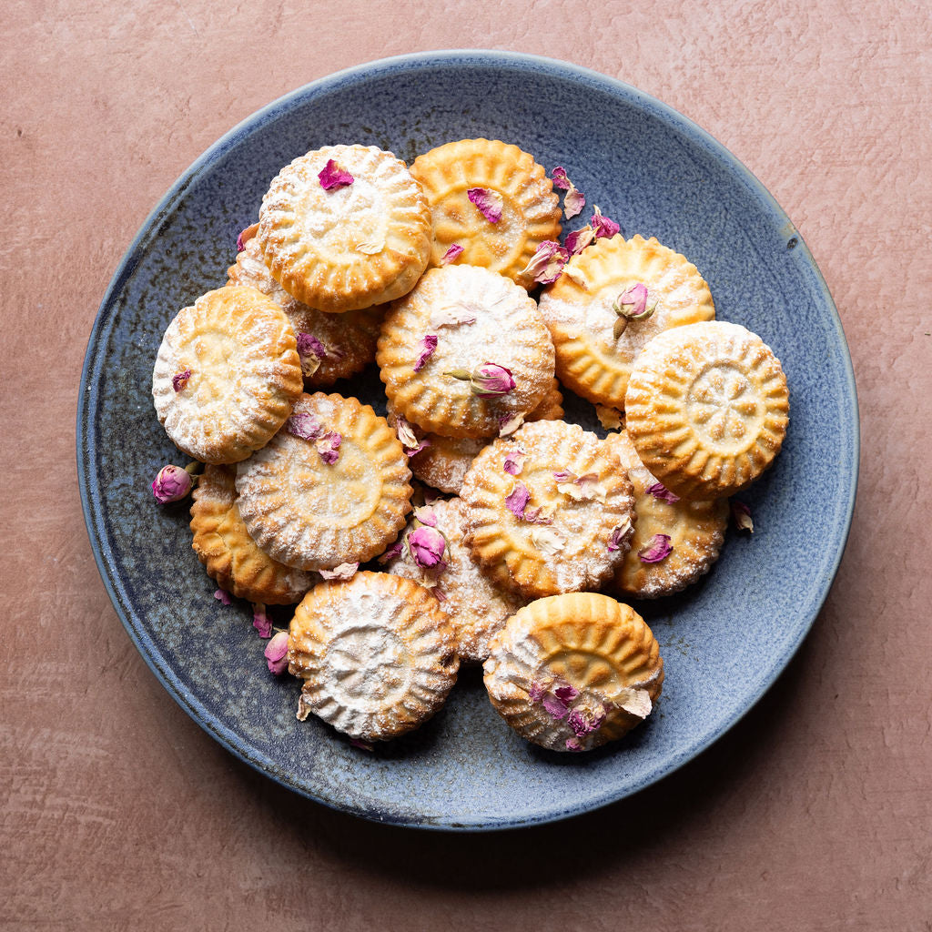 A plate of Mamoosh ma'amoul decorated with dried flowers